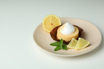 Plate with lemon cupcake on white background