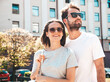 © halayalex - Portrait of smiling beautiful woman and her handsome boyfriend. Woman in casual summer clothes. Happy cheerful family. Female having fun. Couple posing on the street background in sunglasses