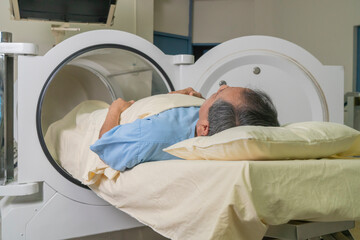 man lying on a stretcher starting hyperbaric treatment