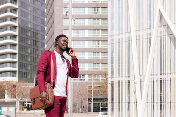 elegant black man with briefcase talking on phone