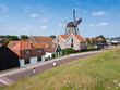 village of oudeschild with windmill on dutch island of texel seen from dike