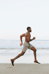 Wall Mural - Fit man running at the beach in the early morning