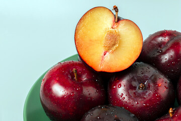 Wall Mural - Side view of big red plums on green plate.