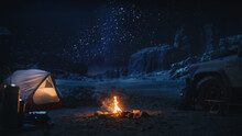 People Camping At Night In The Canyon, Preparing To Sleep In The Tent. Campfire Barely Burning, Truck Nearby. Amazing Natural Landscape View With Marvelous Bright Milky Way Stars Shining On Mountains