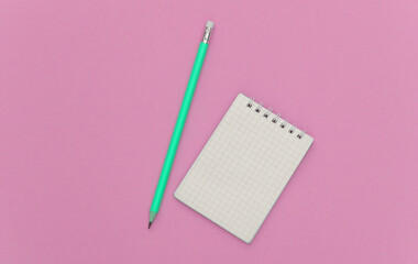 Wall Mural - Notebook with pencil on pink pastel background. Top view