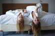 © Aleksandra Iarosh - mom and daughter lie on the bed in white hotel robes after a shower