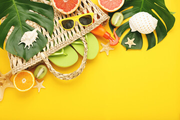 Wall Mural - Summer bag with fresh fruits, monstera leafs and seashells on yellow background