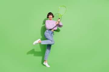 Wall Mural - Full length body size view of attractive cheerful girl playing tennis having fun isolated over bright green color background