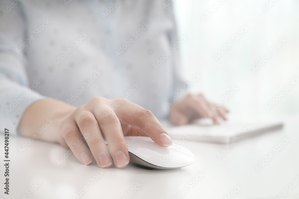 Woman using computer mouse at desk, closeup - obrazy, fototapety, plakaty 