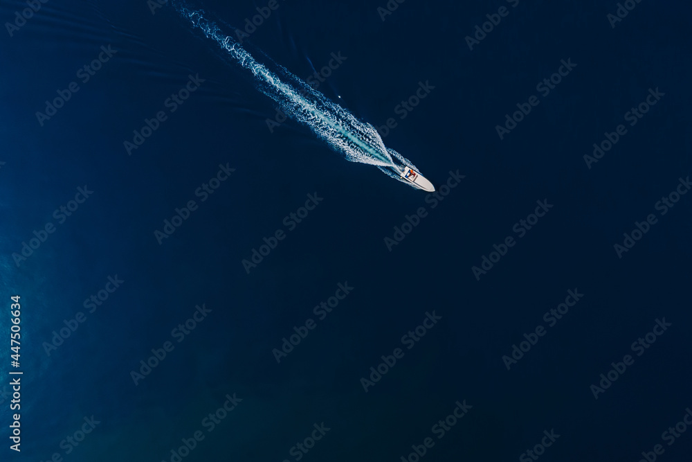 Speedy motor boat is sailing in blue ocean. Aerial view - obrazy, fototapety, plakaty 