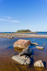 Sticker - picturesque coastal landscape on the Baltic Sea with a small red cottage on an island behind a sandy beach under a blue sky