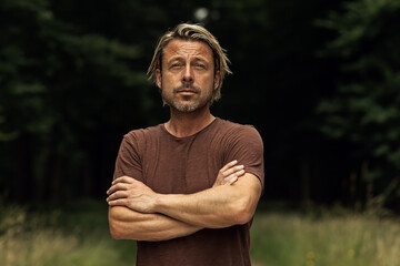 Canvas Print - Blonde man with his arms folded and a stubble beard in a brown t