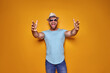© zamuruev - Young handsome man wearing casual t-shirt standing over isolated yellow background pointing with finger to the camera and to you, hand sign, positive and confident gesture