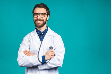 Wall Mural - Portrait young bearded doctor with stethoscope over neck in medical coat standing against isolated blue background.