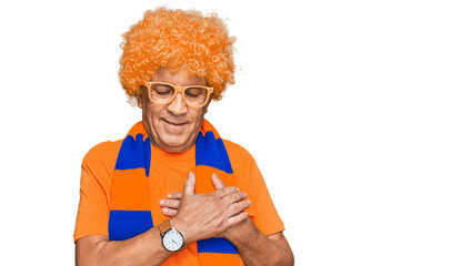 Poster - Senior hispanic man football hooligan cheering game smiling with hands on chest with closed eyes and grateful gesture on face. health concept.