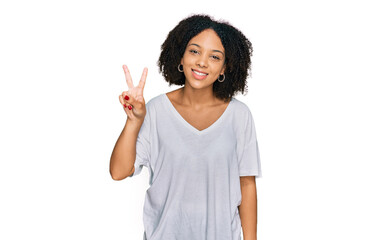 Sticker - Young african american girl wearing casual clothes showing and pointing up with fingers number two while smiling confident and happy.