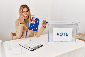 Sticker - Blonde beautiful young woman at political campaign holding australian flag annoyed and frustrated shouting with anger, yelling crazy with anger and hand raised