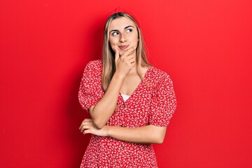 Poster - Beautiful hispanic woman wearing summer dress with hand on chin thinking about question, pensive expression. smiling with thoughtful face. doubt concept.