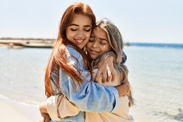 Young lesbian couple of two women in love at the beach. Beautiful women together at the beach in a romantic relationship