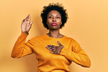 Wall Mural - Young african american woman wearing casual clothes swearing with hand on chest and open palm, making a loyalty promise oath