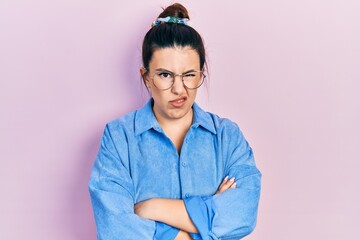 Sticker - Young hispanic woman wearing casual clothes and glasses skeptic and nervous, disapproving expression on face with crossed arms. negative person.