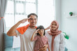 © Odua Images - excited indonesian family supporter giving salute to camera