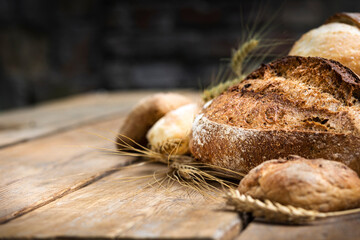 Aufkleber - Assortment of different types of bread from rye and wheat flour on a wooden table in a bakery. Сopy space