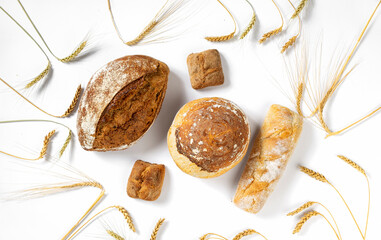 Aufkleber - Bakery. Set of freshly baked crispy bread and buns with ears of wheat on white background top view, flat lay