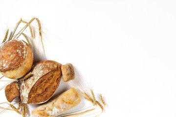 Aufkleber - Bakery. Set of freshly baked crispy bread and buns with ears of wheat on white background with copy space, top view flat lay