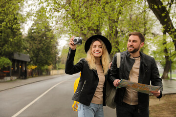 Poster - Couple of tourists with map and camera on city street