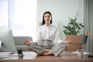 Young woman meditating at workplace. Stress relief exercise