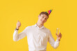 © Pixel-Shot - Handsome man with glass of champagne showing thumb-up on color background
