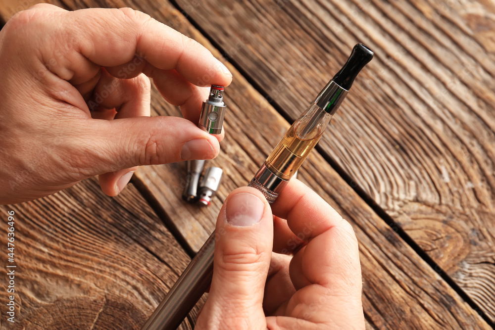 Man with electronic cigarette at table