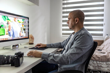 Image correction in a photo processing program. A man in the home office sits at a desk next to a black professional camera with a lens