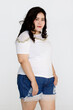 © Bangkok Click Studio - Portrait half body shot of Asian young happy cute friendly overweight fat teen long black hair female wears white shirt and short blue jeans stand smiling look at camera against white background.