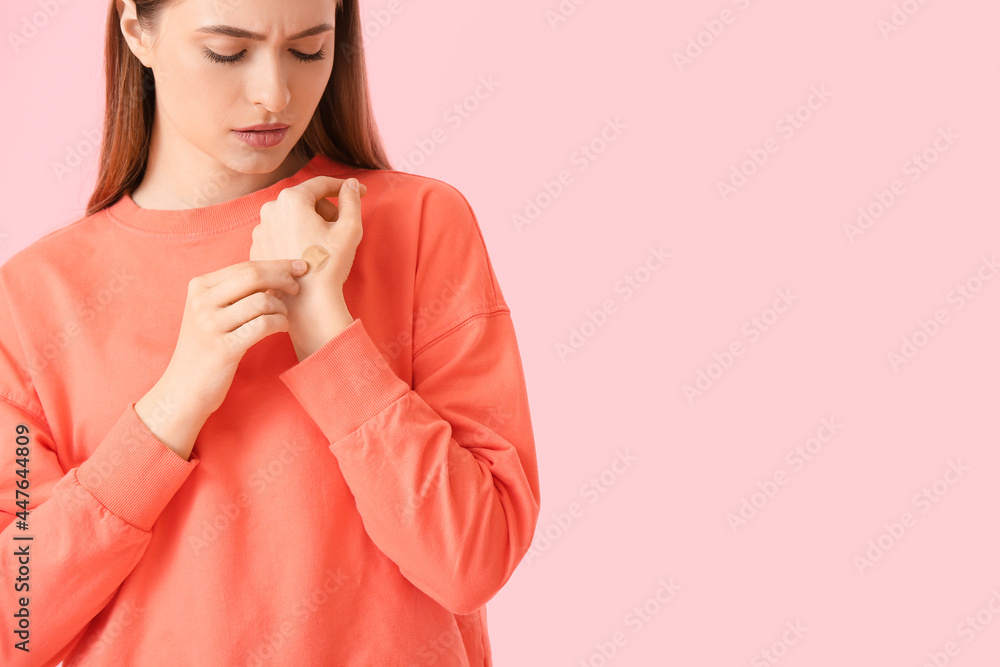 Young woman with applied medical patch against color background