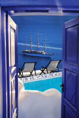 Wall Mural - Santorini island view with ship against swimming pool in Greece