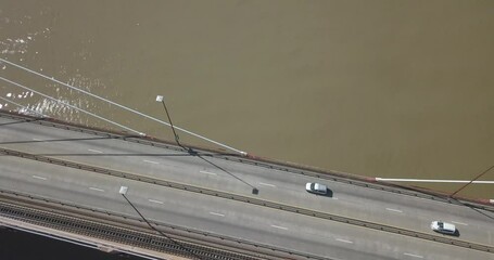 Wall Mural - The cars pass over the bridge over a huge river one sunny day.