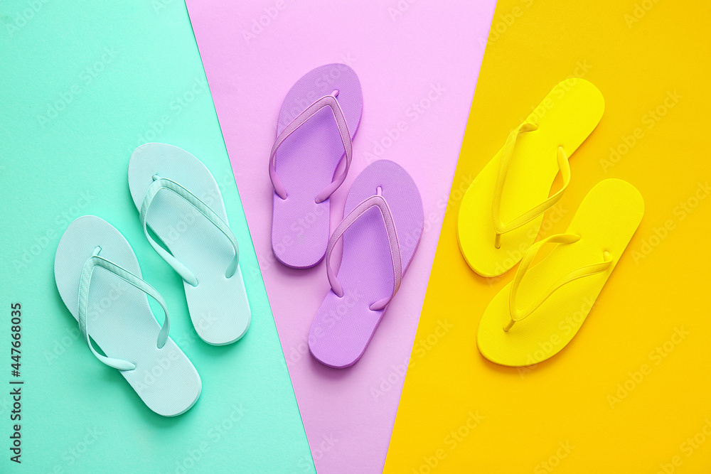 Set of stylish flip-flops on color background