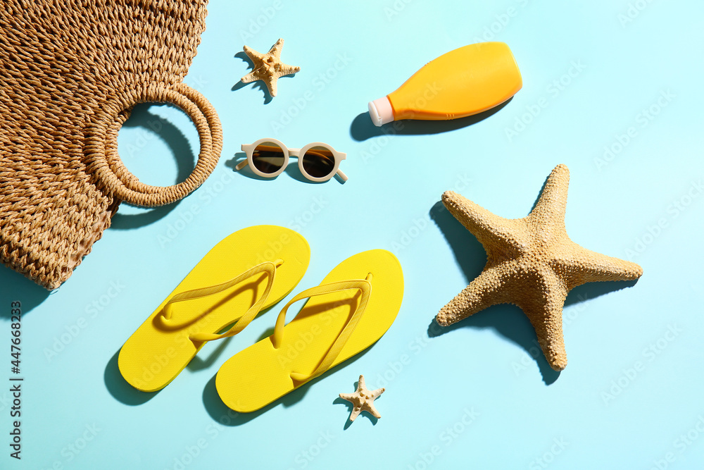 Composition with flip-flops, bag, sunglasses and sunscreen cream on color background