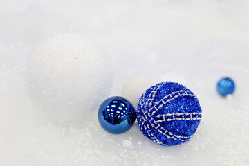 Wall Mural - Blue Christmas balls on white snow background. New Year toys, decorations for greeting card