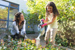 © Wavebreak Media - Happy mixed race mother and daughter watering flowers