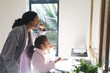 © Wavebreak Media - Midsection of mixed race mother and daughter brushing teeth in bathroom