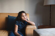 © Wavebreak Media - Mixed race bored girl sitting on sofa in living room