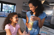 © Wavebreak Media - Happy mixed race mother and daughter cooking together in kitchen