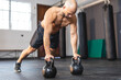 © Wavebreak Media - Caucasian man exercising at gym, doing push ups using weights
