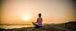 © Melinda Nagy - woman in white doing yoga and meditating by the sea