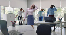 Cheerful Diverse Colleagues Doing Neck Stretching Exercise Standing In Office