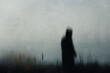 A sinister hooded figure standing in a field, out of focus. With a low camera angle. With Buttercups in the foreground.