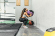 © Cavan Images - woman doing Wall Ball Shot in squat position in gym doing crossfit